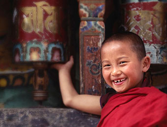Child at prayer wheel in Bhutan by Mark Tuschman