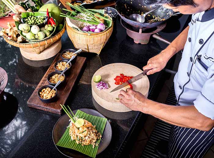 Thai chef chopping ingredients during cooking class