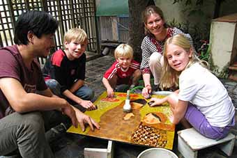 Family creating lacquer art in Hanoi with artist