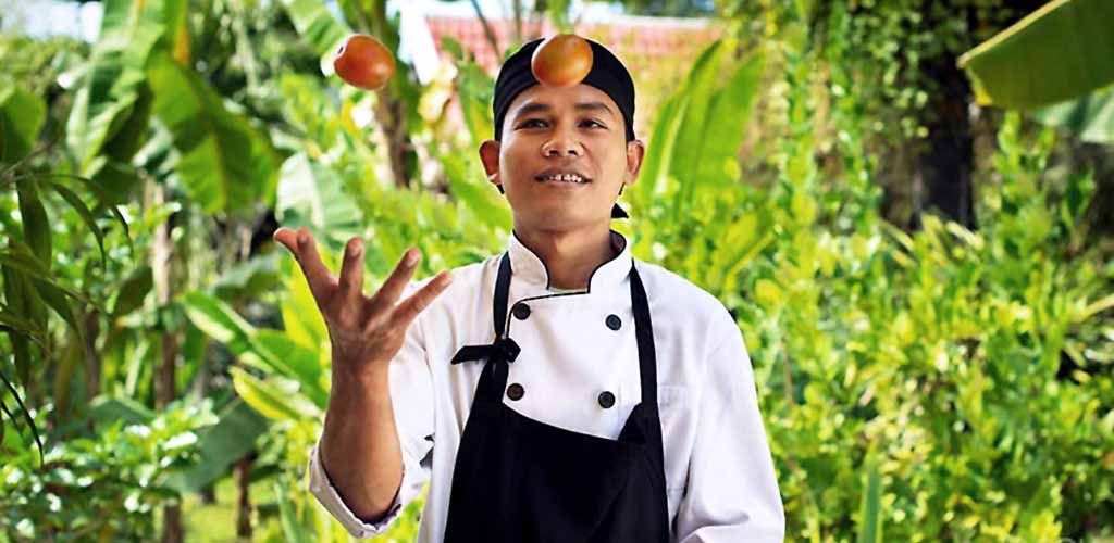 Cambodia chef tossing fruit.