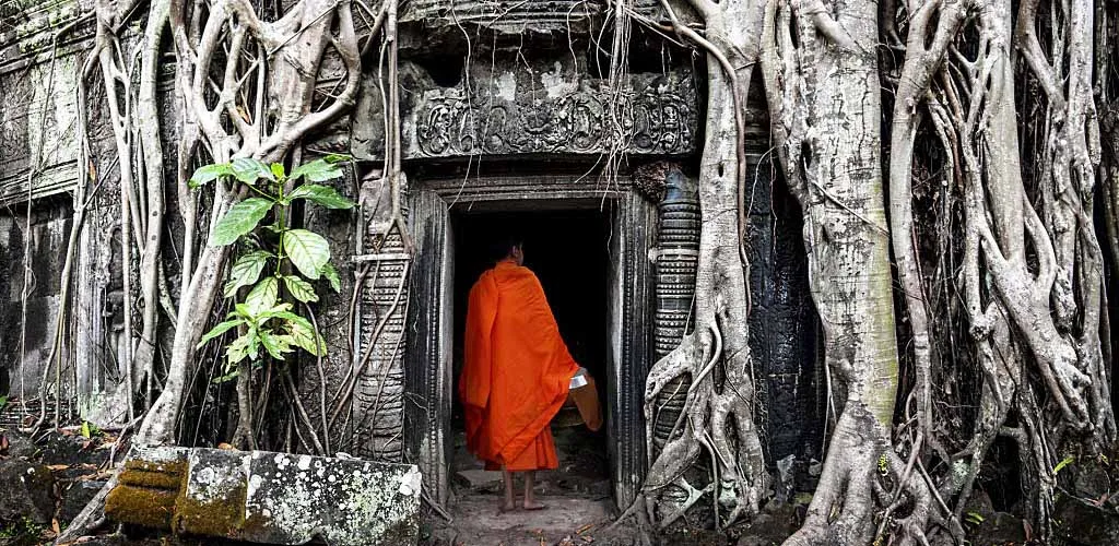 Monk entering Ta Phrom temple in Angkor