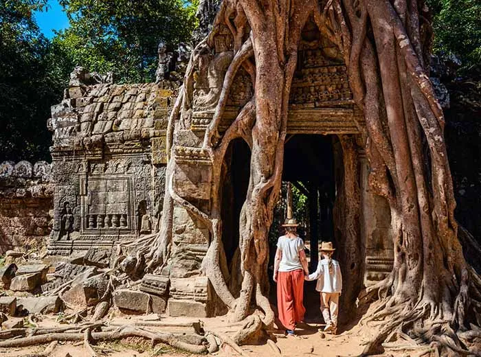 Family exploring temple at Angkor complex in Cambodia