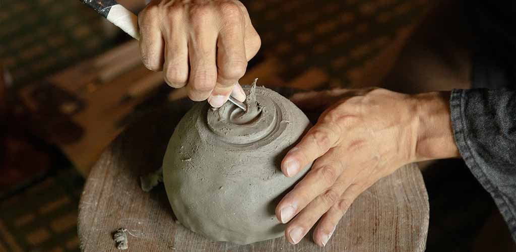 Pottery craftsman carving tea cup in Ishikawa Japan