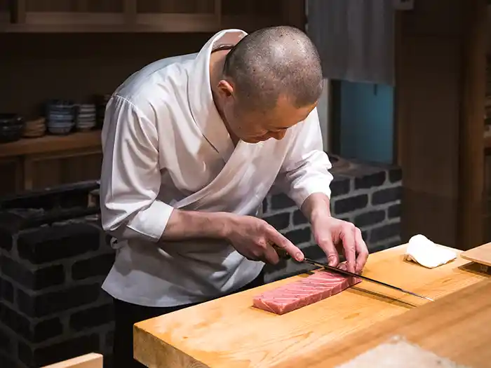 Sushi chef at bar in Tokyo, Japan