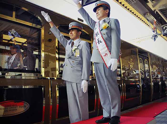Porters on Seven Stars luxury train in Kyushu, Japan