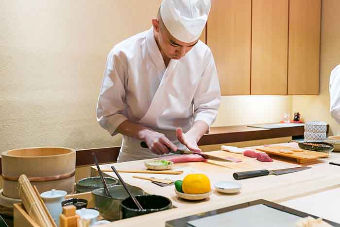 Suschi chef preparing sashimi in Tokyo, Japan.