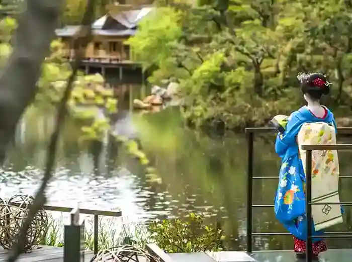 Geisha overlooking pond and garden in Kyoto