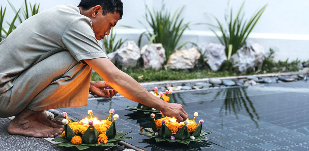 Candlelight lighting ritual at luxury hotel in Luang Prabang, Laos