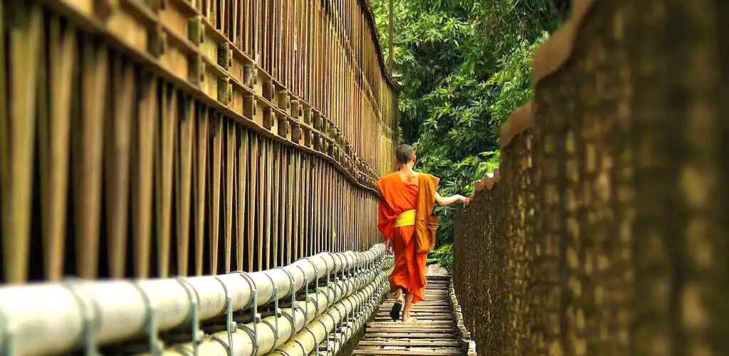 Monk crosssing bridge in Luang Prabang