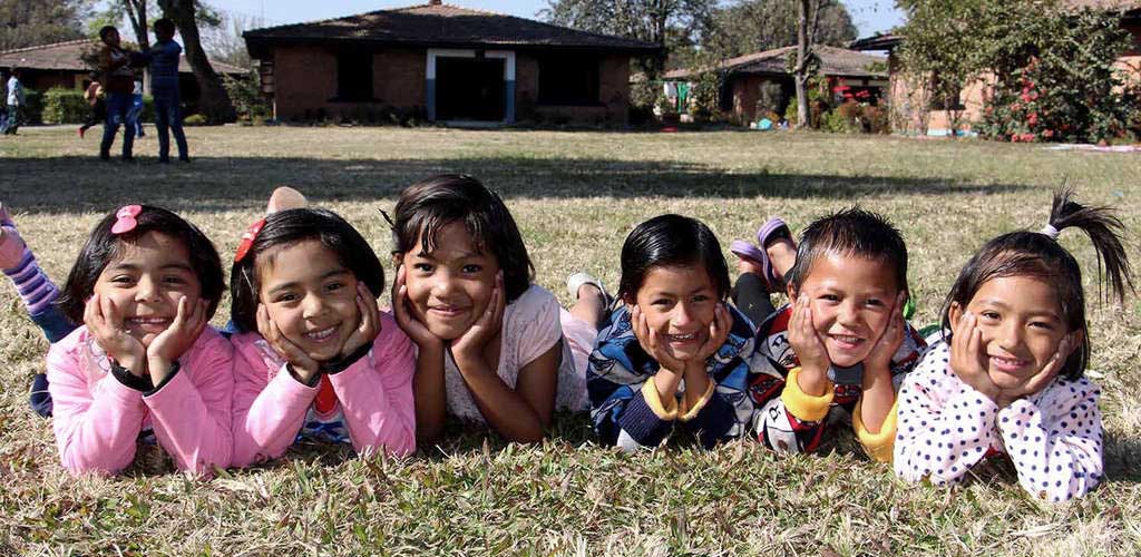 SOS Children's Village nonprofit smiling kids on lawn