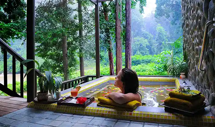 Woman soaking in outdoor hot tub at the Borneo Rainforest Lodge, Danum Valley, Borneo