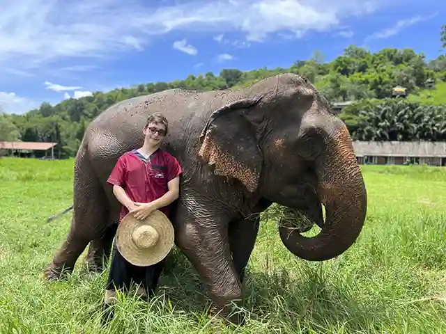Boy visitor with elephant at Rantong elephant sanctuary