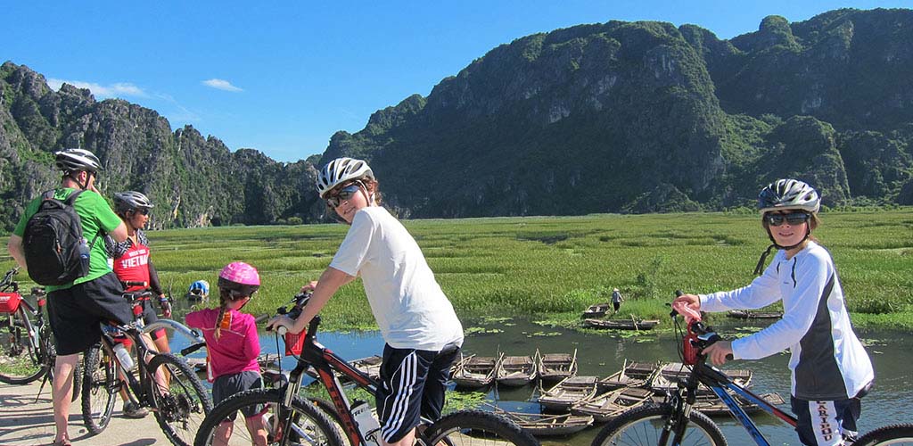 Family cycling in Ninh Binh during a bicycle tour of Vietnam