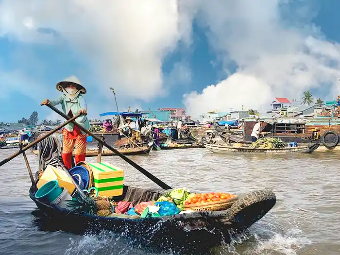 Boat vendor rowing in floating market on the Mekong River, Vietnam