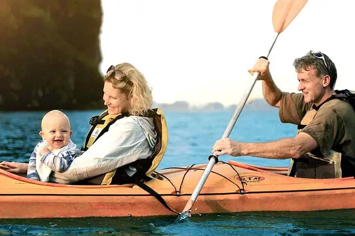 Family with baby kayaking on Halong Bay, Vietnam