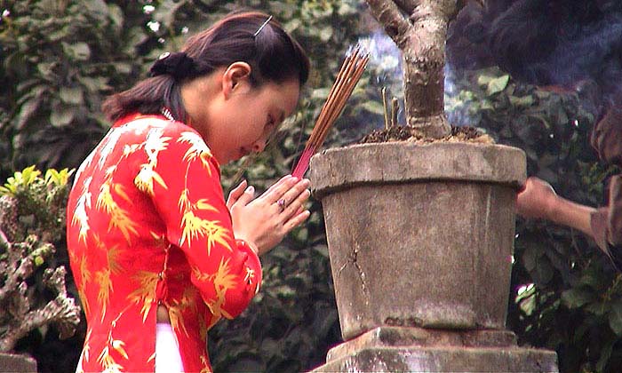 Girl praying at one pillar pagoda, Hanoi, Vietnam