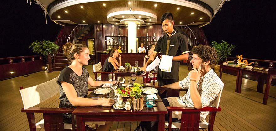 Dining on the deck of a Halobg Bay luxury ship charter