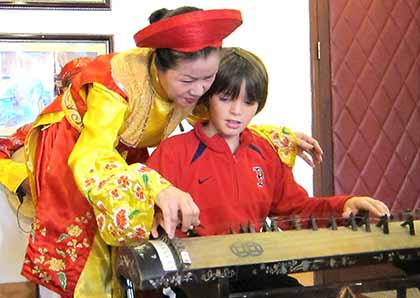 Child playing the dan bau, a Vietnamese traditional instrument