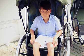 Boy enjoying cyclo ride in Hanoi, Vietnam