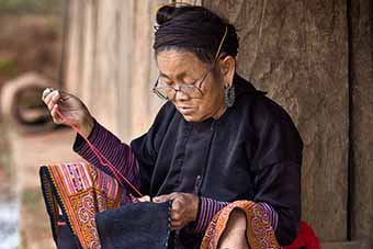 Elder Flower Hmong sewing in village, Vietnam